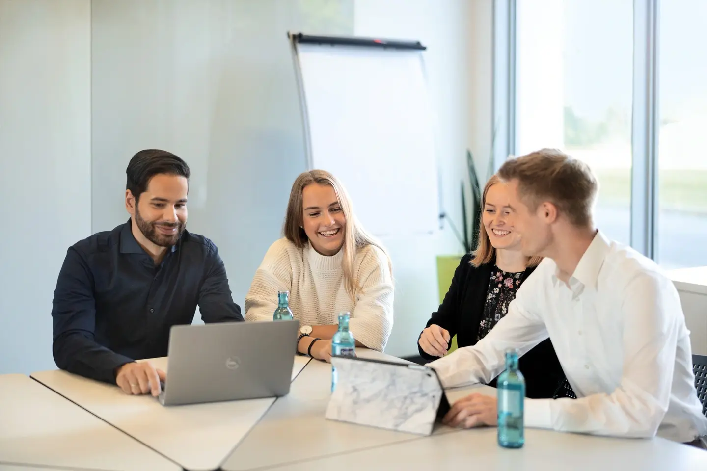 Picture - Vier Personen sitzen in einem Besprechungsraum